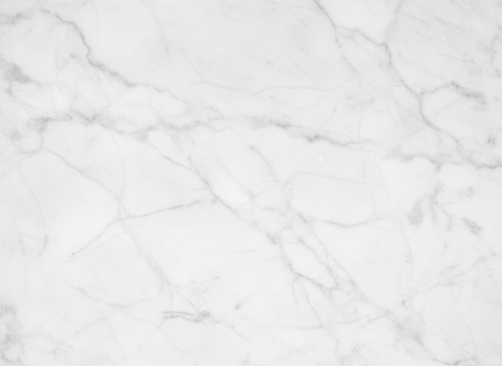 Close-up photograph of white marble surface with subtle grey veining, natural stone material